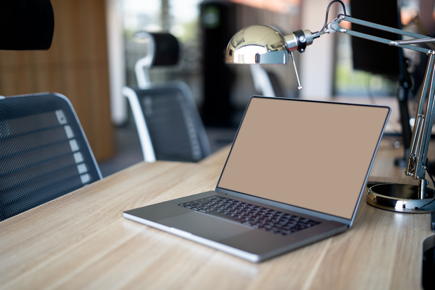 Ein moderner Laptop steht auf einem hellen Holztisch.